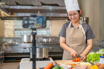 Young Asian Female Chef Vlogging Slicing Vegetables