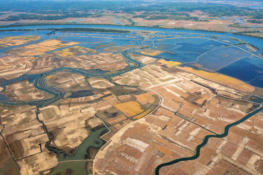 Aerial view of a network of waterways cuts through the landscape of rice paddies and fields, creating a tapestry of textures and tones, Teknaf, Chittagong Division, Bangladesh.
