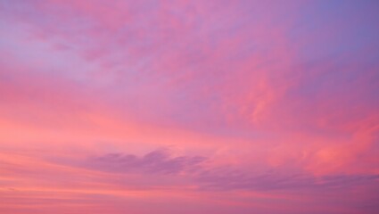 Obraz premium Vibrant pink and purple hues paint a soft dreamy sky filled with wispy clouds at sunset or sunrise