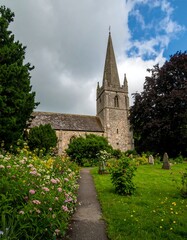 Fototapeta premium A quaint church nestled amongst gardens and a graveyard
