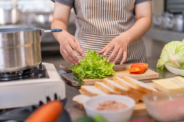 Close-up of a chef's hands preparing lettuce on a wooden cutting board