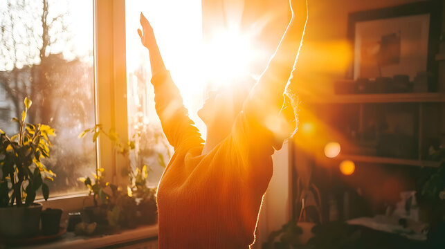 Person stretches arms towards warm sunlight streaming through a window.  Sunlight highlights the silhouette of the person, who appears happy and energized. Plants are visible in the foreground