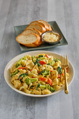 tortellini primavera with broccoli, carrot, and tomato in a parmesan garlic cream sauce