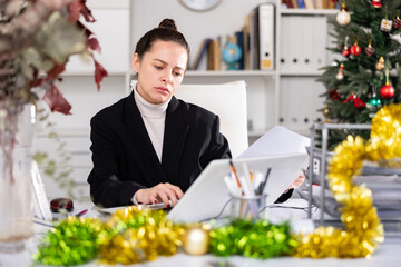 Woman manager working at computer during christmas holidays