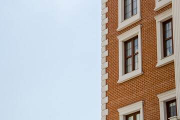 Detail of a red brick building with blue sky in the background
