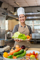 Happy Young Asian Female Chef Holding Fresh Vegetables