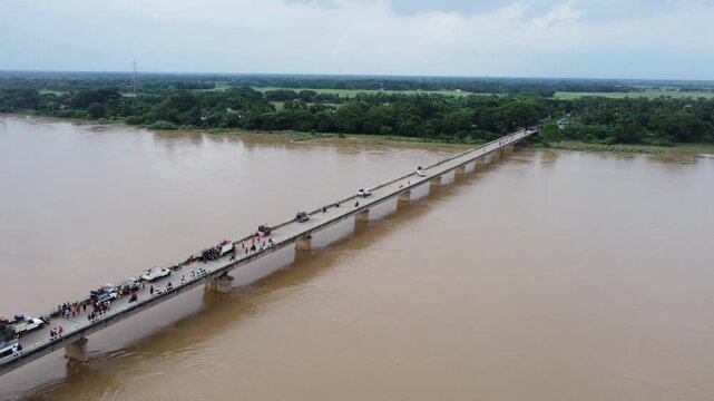 Bridge over river. drone flying over a concrete bridge running across the flooded river in asian rural area.