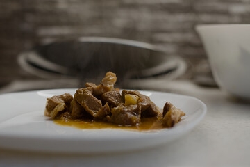 Hot fresh meat and potato dish on a white porcelain plate