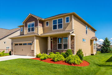 A sprawling  home with symmetrical windows, gabled roofs, and a wraparound porch—epitomizing refined American homeownership..