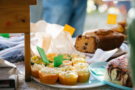 Outdoor display of baked goods like cupcakes and bread.