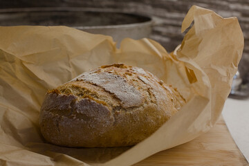Freshly baked bread unwrapped on a baking paper