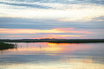Beautiful sunrise on the lake shore early in the morning.