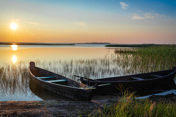Traditional wooden fishing boat with oars on the lake shore.