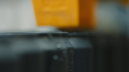 Close up of a robotic arm picking and placing aluminum cans on a conveyor belt in a beverage...