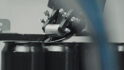 Conveyor belt transporting aluminum cans for sealing process in modern beverage factory, showcasing automation and efficiency in industrial production line
