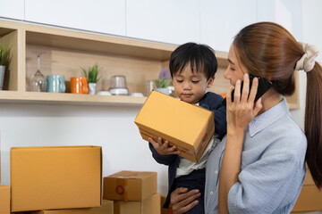 Mother on Phone While Holding Child and Managing Boxes