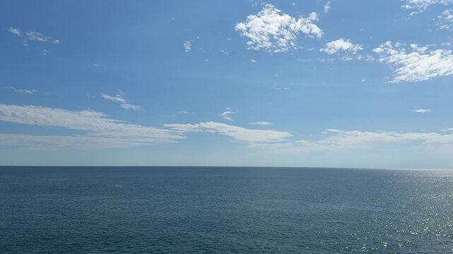 Blue shining ocean, sky and clouds.