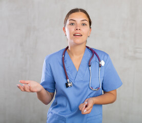 Portrait of young female medic in medical uniform posing in studio..