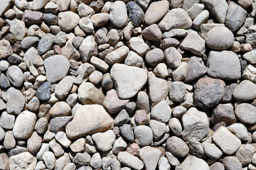 Abstract background with brown and beige dry stones, cobblestones, gravel. Gravel texture or...
