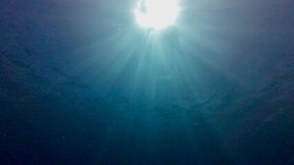 View of the sun from underwater. View of the sun and sun rays from the bottom of the sea through the thickness of water. Sun crown underwater.