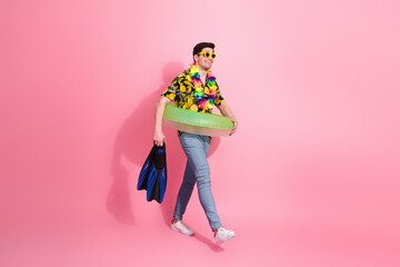 Bright summer vibes with young man in tropical outfit holding swim gear against vibrant pink...