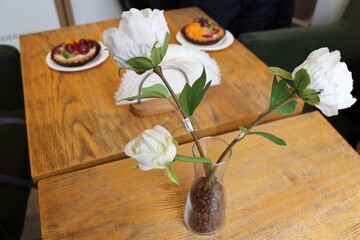 Cupcakes in a vase on a wooden table in a cafe