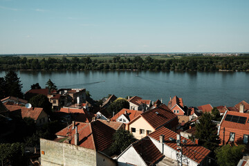 Panoramic view of red-roofed houses in Zemun, Belgrade, by the calm Danube River on a sunny summer...