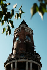 Obraz premium Close-up view of the top of Gardos Tower in Zemun with leaves blurred in foreground. A symbol of old town charm and Austro-Hungarian heritage in Belgrade.
