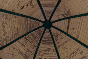 A Unique Perspective of a Vintage Gazebo Roof Showcasing Intricate Wooden Patterns and Decorations...