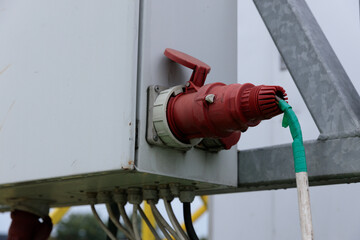Close-Up View of a Red Electrical Connection Positioned on Industrial Equipment with a Green and...