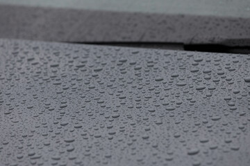 Close-up View of Raindrops on a Car Surface Captured in Natural Light, Showcasing the Beauty of...