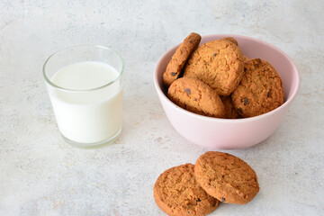homemade oatmeal cookies in pink bowl with a glass of milk