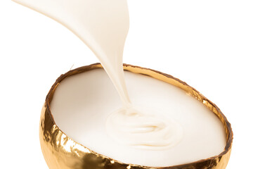 a white liquid pouring out of a golden coconut