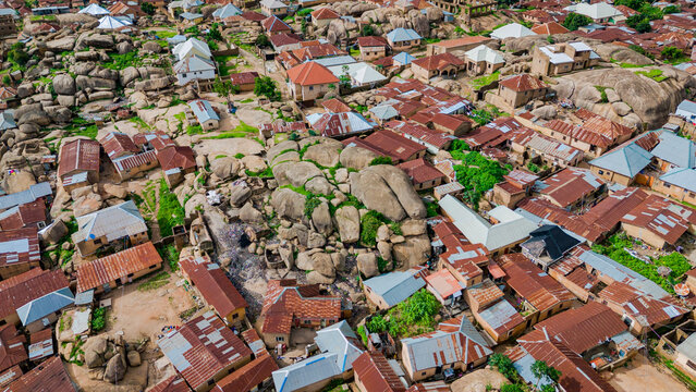 Aerial view of dwellings nestled amidst striking rock formations, a blend of rustic rooftops and natural textures, Jos, Plateau, Nigeria.
