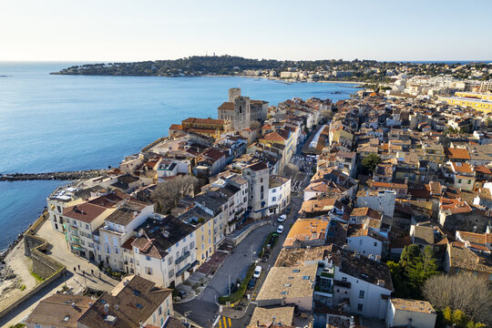 Aerial view of the historic Ch&Atilde;&cent;teau Grimaldi and the old town's terracotta rooftops meet the turquoise waters of the Mediterranean Sea, Antibes, Provence-Alpes-C&Atilde;&acute;te d'Azur, France.