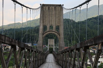 Fototapeta premium 歴史的な木造吊り橋と山の風景が美しい長野県の桃介橋