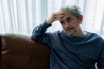 depressed senior man sitting unhappy with head in hand, old asian elderly feeling sad suffering from health problems. Upset lonely mature male distressed with loneliness solitude