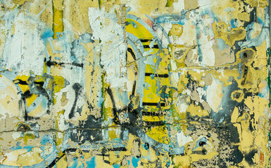 Abstract: crumbling graffiti on a city street wall. Colorful abstract background. Old, cracked, peeling paint serves as a background.