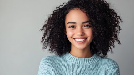 Young woman with curly hair smiles