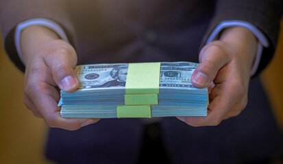 Businessman holding money banknotes and making decision for business investment. Selected focus