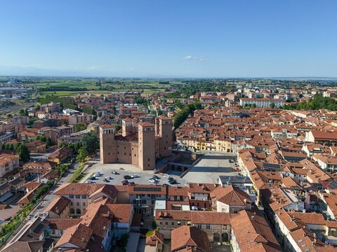 Aerial view of the imposing Castello degli Acaja stands proudly amidst the terracotta rooftops and verdant landscape, Fossano, Piemonte, Italy.