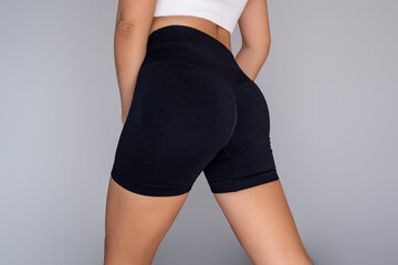 Close-up of young woman wearing black shaping shorts that emphasize her curves and sculpt the body....