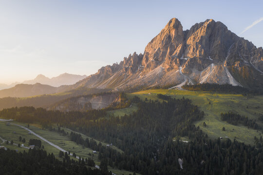 Aerial view of golden sunlight kissing the rugged peaks and verdant slopes near Wurzjoch, a tapestry of nature's artistry, Passo delle Erbe, South Tyrol, Italy.