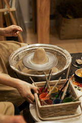 Fingers pressing and smoothing wet clay