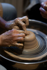 Potter’s hands forming clay sculpture 