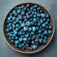 Fresh blueberries in a ceramic bowl. Close-up, free space for text.