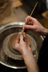 Artist forming clay cup manually