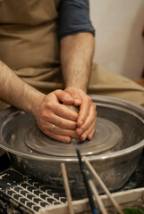 Wet clay on wheel forming a cup 