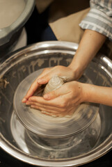 Hands crafting on pottery wheel 