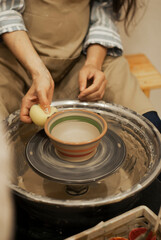 14. Potter shaping a clay jug on wheel